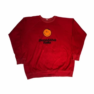 BeneAkiva Italia - Vintahe Sweatshirt - En cool röd sweatshirt med tjockt tyg. Den har en cool lite mer 90s smiley som ger en cool känsla. Köpt på en amerikansk secondhandbutik. 