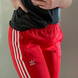 Röda Adidas byxor strl S - Byxorna är i en fin stark röd färg, och säljs då de inte kommer så mycket till användning. Byxorna är i bra skick, och är använda fåtal gånger!