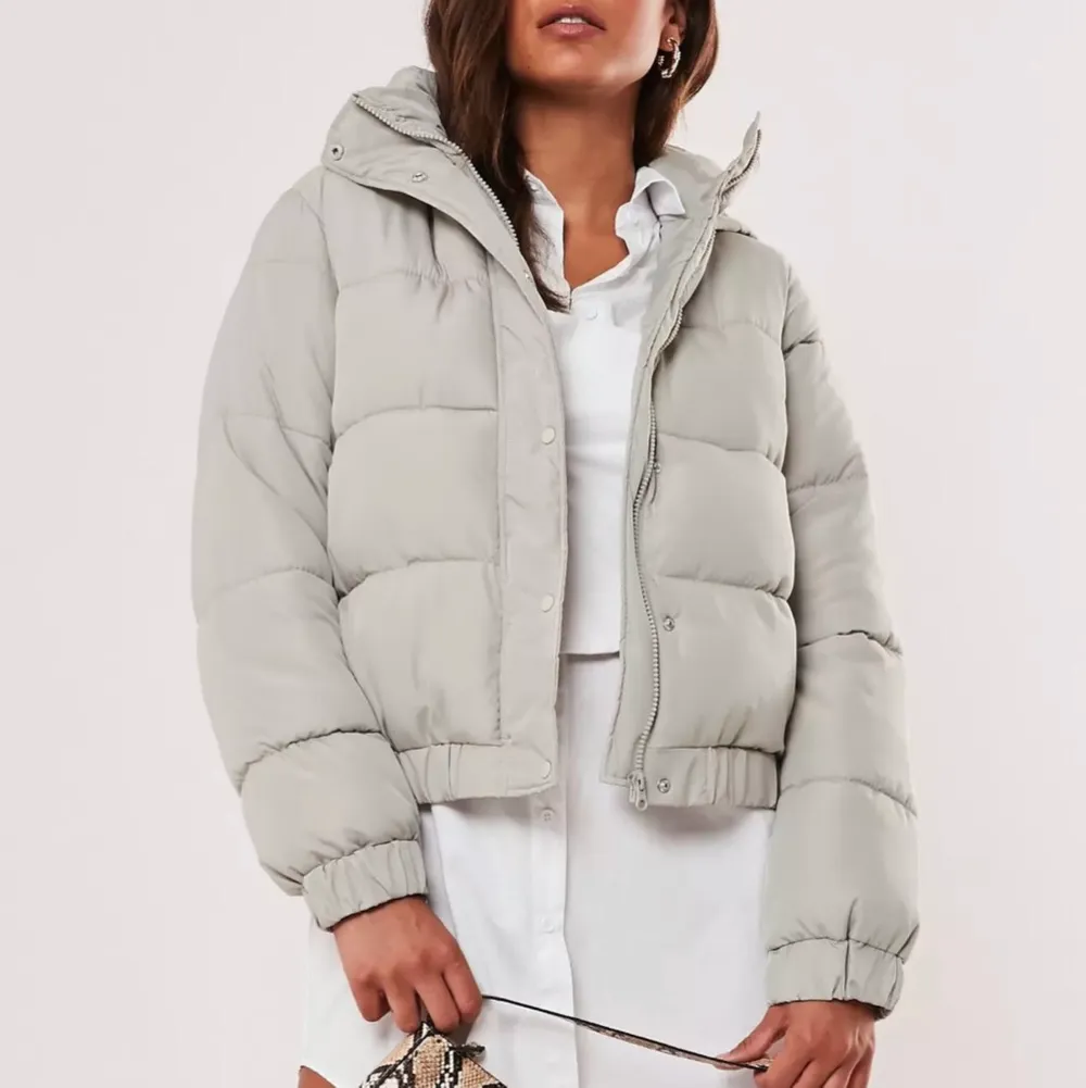 Trendig cropped pufferjacket ifrån Missguided i nyskick, ej använd alls & prislappar kvar🤍 Storlek 38 och i en Beige/ljusgrå jättefin färg🤍 Nypris: 830kr, mitt pris: 390kr🤍. Jackor.