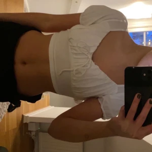 Vit topp  - Säljer en denna helt oanvända toppen pågrund av att den tyvärr inte kommer till användning. Den är justerbar då det är knytningar i ryggen. Bara att skriva för fler bilder så fixar jag det! 