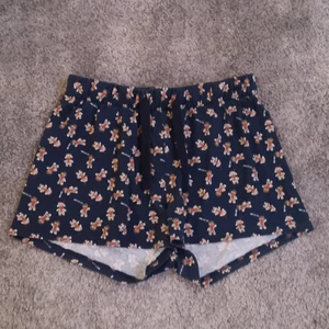 Marinblå pyjamas shorts med pepparkakor  - Marinblå pyjamas shorts med pepparkakor på ifrån cubus. Knappt använda och i väldigt fint skick. Snören så att man kan spänna/knyta dem och resor i midjan. Storlek: xs