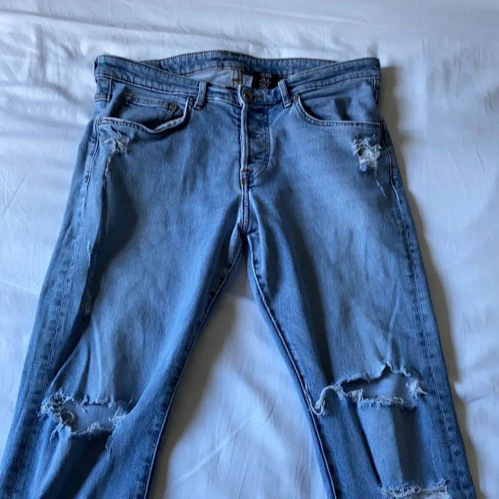 Ljusblå slitna jeans i storlek 34”32. Jag är 175cm och jeansen sitter bra i längden men är för tighta. Det har gått sönder men sytts igen vid rumpan, det är dock inget som syns eftersom det är långt bak. Bor i Norrköping och kan mötas upp, annars står köparen för frakten. Pris kan diskuteras!. Jeans & Byxor.