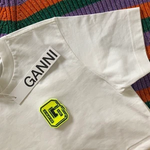 Ganni t-shirt  - fin ganni t-shirt med två olika märken på bröstet som man kan byta!! använd därav deg billiga priset💛❤️‍🔥