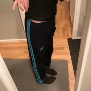 Adidasbyxor - Mörkblå adidasbyxor med neonblå sträck. Jag är 168 och dem är pyttepyttelite långa men det är bara snyggt. Skriv för fler bilder. Frakt blir runt 60❤️