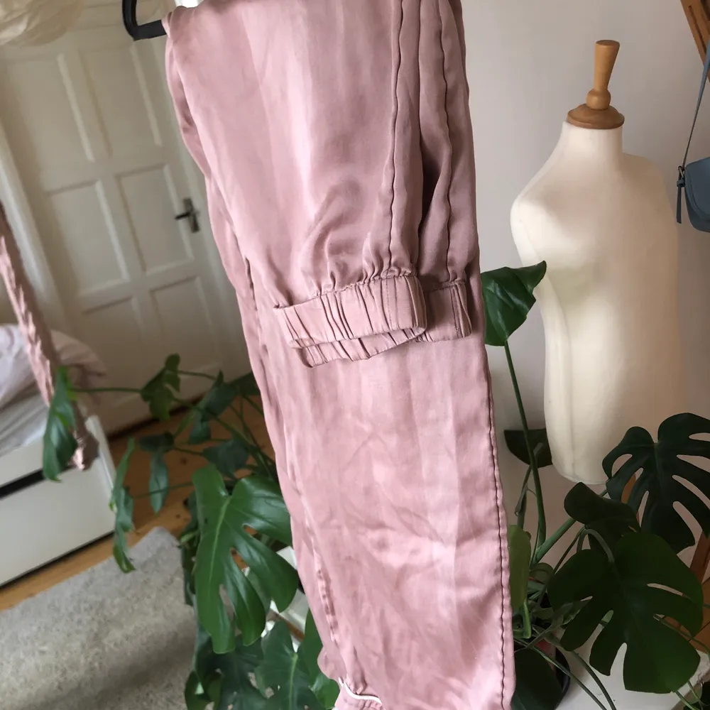 Ett par pyjamasbyxor i en typ dusty rosa silke. Dessa är från H&M och är i storlek 36. Skriv för fler bilder eller info💗🤌🏻. Jeans & Byxor.