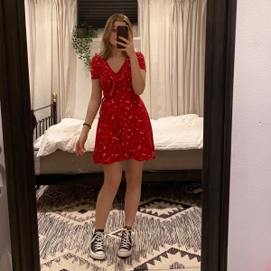 Röd omlottklänning - Skitgullig röd omlottklänning som tyvärr inte använts så mycket som den förtjänar! Tycker inte färgen passar mig🖤 Jag brukar ha XS-S och jag är 165cm lång! Eftersom man knyter i midjan själv passar den nog ganska många:) Det blir budgivning om fler är intresserade!