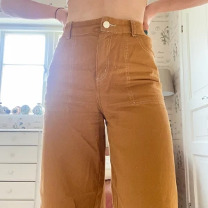 Monki byxor - Orangea byxor från monki. Sitter jättefint och är väldigt bekväma. De finns inte längre att köpa på Monki. 