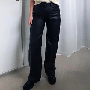 Byxa i fuskläder stl 38 - Helt nya byxor. Oanvända  Ordinarie pris  350kr.   Dessa byxor är ett par 5 ficksbyxor i mjuk läderimitation. Byxorna har hög midja och vida ben. Gylf med dragkedja och knapp i midjan.