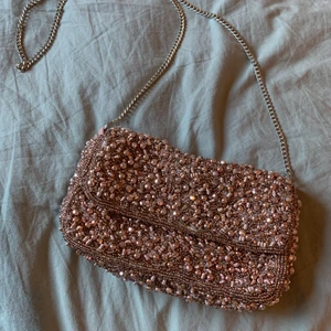 Väska med pärlor - Säljer denna fina väska från Zara. Roséguld med pärlor och silvrig tunn kedja. Endast använd en gång, nyskick. Går även att använda som clutch.