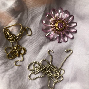 Berlock och tillhörande kedjor - Supersöt lila berlock formad som en blomma utsmyckad med fina stenar!🌸 Ganska stor men otroligt fin vintagestil perfekt till en drömmig outfit. Köpt på en exklusiv dansk designbutik som inte längre finns. Tillkommer även två kedjor (osäker på materialet men förmodligen färgade eller pläterad med silver och brons). Köparen står för frakten✨