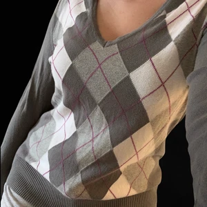 90 TALS INSPIRERAD ARGYLE TRÖJA - Trendig vintage 90 tals inspirerad argyle mönstrad tröja i grå, lila och vita färger. Storleken är L men skulle säga att den passar S/M. Från (United colors of benetton) bra skick! 💜🤍💜🤍