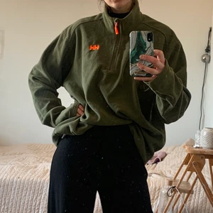 Fleecetröja från Helly Hansen - Riktigt varm och mysig olivgrön oversize fleecetröja med orangea detaljer. Perfekt om du gillar oversize polo-looken✨🌸🌿frakt inkluderat!