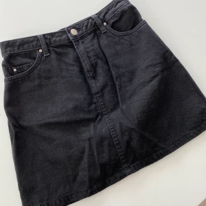 Svart jeanskjol - Så fin svart jeanskjol i väldigt fint skick, är mycket svartare än vad den ser ut på bilden. Säljer pågrund av att den är förliten för mig. Kontakta mig vid frågor, frakt tillkommer. 