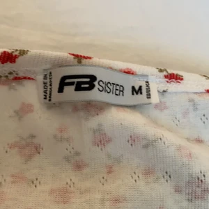 Strl M - En topp med mönster av blommor. Frakt ingår i priset