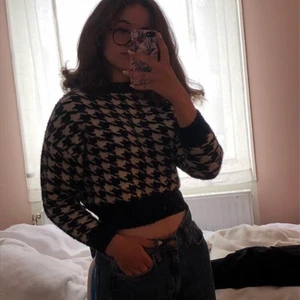 Svart och vitrutig stickad tröja - Snygg magtröja som passar perfa till kyligare väder. 