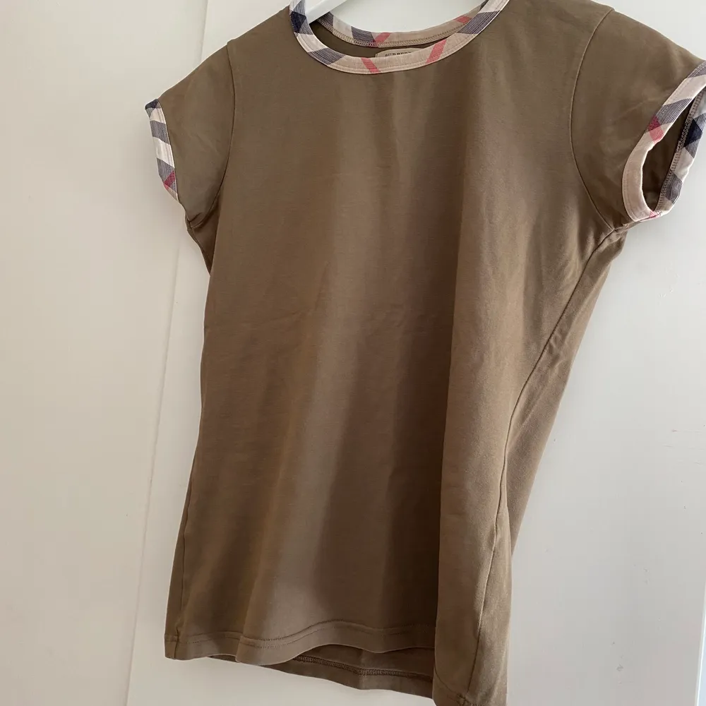 En burberry tröja i storlek s. Den ser grön ut på bilderna men är egentligen brun. Säljer den då jag har en likadan i vit som jag använder oftare. . T-shirts.