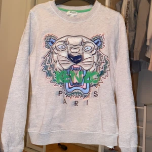 Kenzo Paris tröja  - Äkta Kenzo tröja i st XS. I fint skick , använd några gånger. Fin grå tröja med färglagt tryck!  Köpt för 2700 kr 