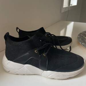 Svarta skor med en vit sula från xit