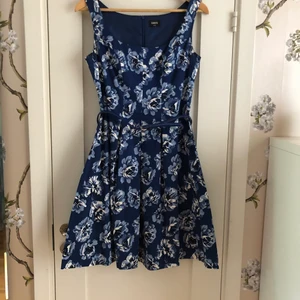 Oasis klänning storlek 10/36 - Färg: Fin blå färg med ljusblå/vita blommor.          Längd: ovanför knäna. Fin passform. Använd en gång. Nypris 900kr. 