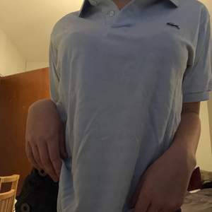 En baby blå lacoste t-shirt