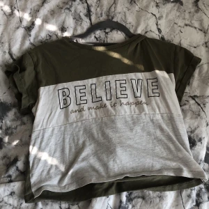 T-shirt  - En t-shirt som är grön vit och grå