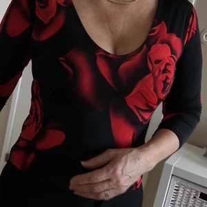 Svart röd topp storlek S - Tight fräck topp från Suksess med röda rosor på svart bakgrund, storlek S. Använd endast en gång, i mycket fint skick. 150kr