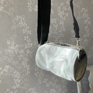 Väska reflex - Väska men justerbart band från weekday. Glittrar i solen och är av reflexmaterial. Knappt använd