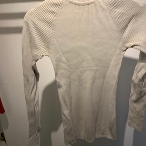 Vit polotröja - En ribbad polotröja i elastiskt material, sitter väldigt bra och är sparsamt använd 