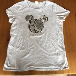 T-shirt - Säljer en tröja med mussepigg på väl använd några gånger storlek: XS säljer för 100kr inklusive frakt 