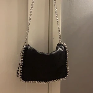 Tiamo Väska🖤 - Tiamo väska som jag använt fåtals gånger. Finns fack både inuti väskan o även på baksidan med dragkedja. Nypriset låg på 450kr. Jag säljer för 200kr. 