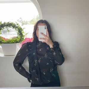 Blommig blus  - Svart, knäppning på vänster sida 