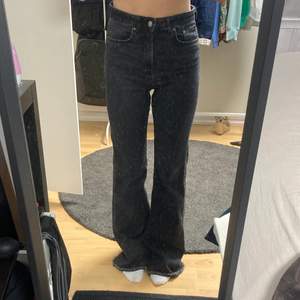 Mörkgrå högmidjade flare jeans som sitter snyggt på benen och rumpan. Säljer dem eftersom att jag inte använder högmidjade jeans. Innerbenslängd 78cm. Den har en defekt (som syns på bild 3) på höger och vänster sida i midjan. Skriv för mer info!❤️