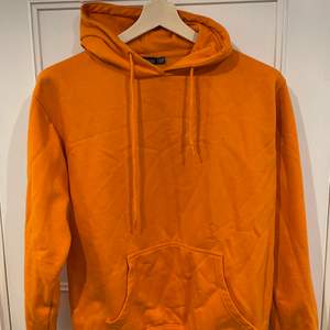 Orange hoodie med tryck på ryggen från boohoo. Använd 1 gång