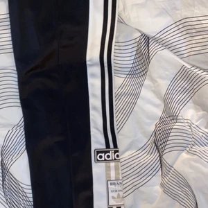 Adidas track pants - Adidas byxor med knappar på sidan storlek 38 aldrig använda