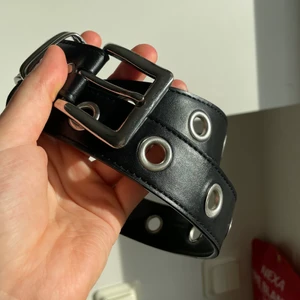 Svart bälte  - Svart bälte i läderimitation med silvriga detaljer. Använt mycket sparsamt