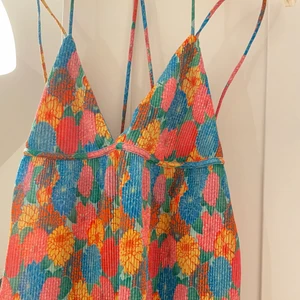 Blommig Topp  - Jättefin oanvänd sommartopp i storlek S som köptes i somras. Använder inte då den är för liten för mig. Fina slitsr på sidorn och passar perfekt till sommaren. HÖGSTA BUD: 110 KR