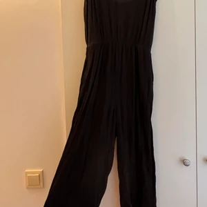 Svart byxdress - Svart byxdress i tunnt material i storlek XS. Kort i benen.