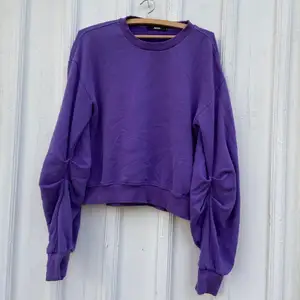 En lila sweater från Bikbok med lite större armar. Den är ”ihopdragen” vid armarna, väldigt snyggt. Bra skick. 