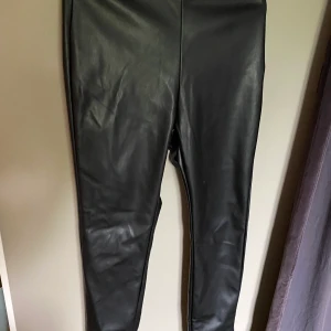 Lödder byxor  - Sjukt snygga läderbyxor från Nelly med slits i slutbenet 