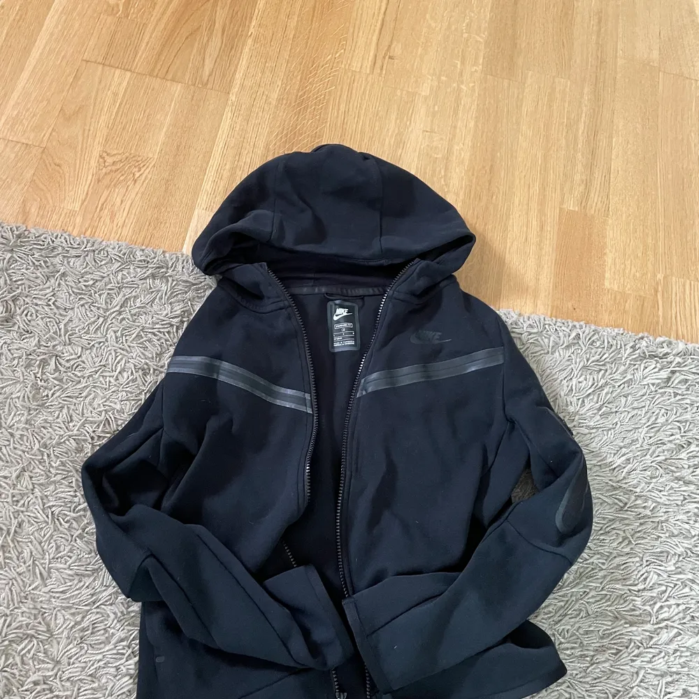 Svart Nike Tech Fleece i utmärkt skick. Köpt för 1100kr men säljer för 600kr. Den passar för folk upp mot 165cm. . Hoodies.