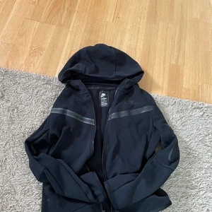 Nike Tech Fleece - Svart Nike Tech Fleece i utmärkt skick. Köpt för 1100kr men säljer för 600kr. Den passar för folk upp mot 165cm. 