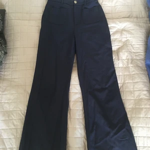 Flared Byxor & Other Stories - Utsvängda byxor i 70-talsmodell från & Other stories. Materialet är en ylle - och viskosblandning så de håller passformen bra. Färgen är marinblå. 