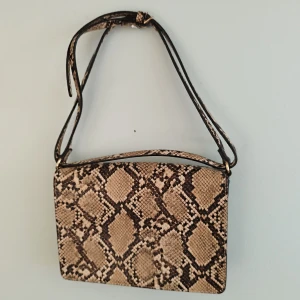 Ormskinn väska HM - Liten ormskinnsväska från HM. Bra skick och kan användas med axelrämm.