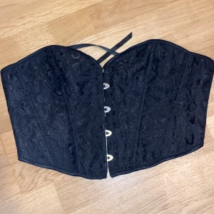  korsett - Svart korsett topp, jätte fin men säljer pga att den inte riktigt håller upp bysten, så skulle ej rekomendera till dig med större byst. 