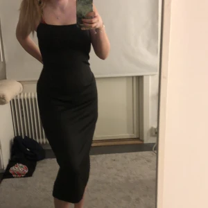 Lång svart klänning  - Säljer denna längre svarta klänning med super lent mjukt material då jag aldrig använder den och den är lite för stor, liten slitt baktill. Står ej vilken storlek men den är väldigt stretchig så skulle säga att man kan ha den från S-L