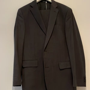 Oscar Jacobsson kostym  - Säljer en fin Oscar Jacobsson kostym. Säljer helst hela kostymen, men kan tänka mig att sälja den delad. Alldrig använd. Mörk grå färg, storlek 48