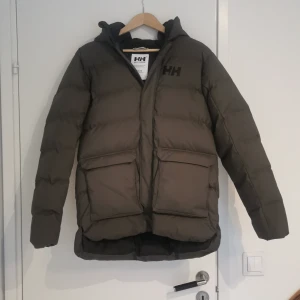 Helly Hansen Jacka  - Säljer en helt ny jacka från Helly Hansen. Strl. 176 Färgen på jackan är mörkgrön.  Ny pris är 1600 kr. Priset kan diskuteras med mig💯