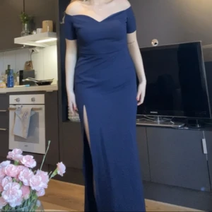 Långklänning - Jättefin mörkblå långklänning med slits som funkar till ex. bal eller bröllop. Den är ganska lång, jag är 174cm och med klackar så släpar den i marken. Stretchigt tyg. Endast testad. (Har bättre bilder)