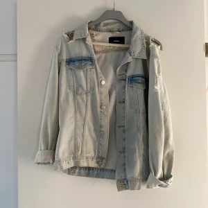 Jeansjacka - Jeansjacka från Bikbok i storlek S, dock oversize i modellen så passar även som en medium. Ganska så ljus tvätt och lite slitningar här och var. Väl använd och i bra skick