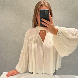 Vit blus - En superfin vit blus från Lindex med fina ärmar och detaljer kring hals ringningen❤️‍🔥. Blusen är i ett bra skick!! Blusen har en knytning där bak med band som hänger ihop med kragen!  Hör av dig med eventuella frågor🧡🧡